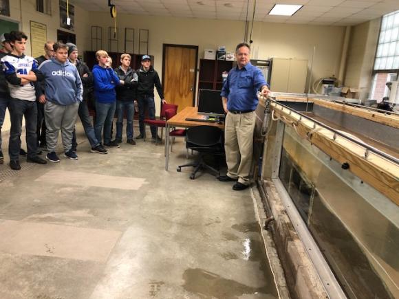 Dr. Brian Barkdoll (Civil & Environmental Engineering) shows students a stream model used to measure the erosion impacts of high stream flows on bridge piers.